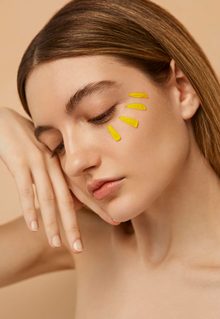 une femme avec des feuilles jaunes sur le visage