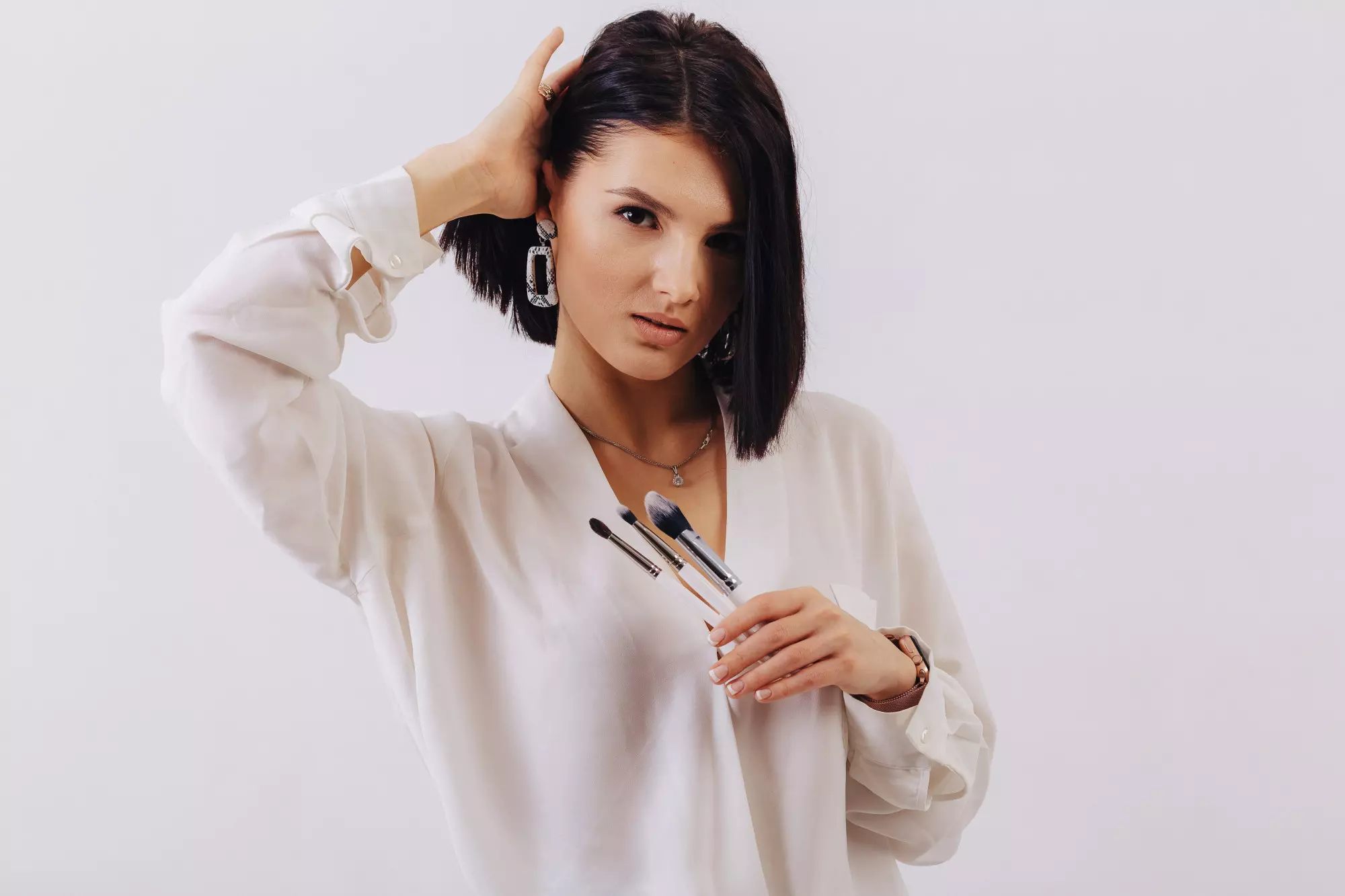brune aux cheveux coupés au carré, en chemise blanche