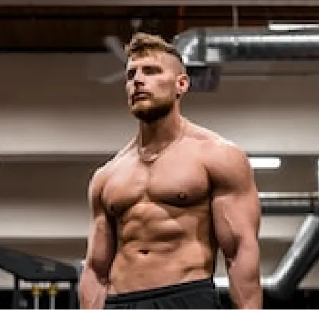 a muscular guy with a naked torso tensed all the muscles on his body