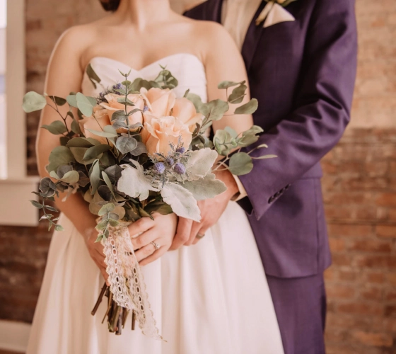 die Braut mit Blumen und der Bräutigam neben ihr