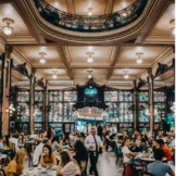 Ein lebhaftes Café mit kunstvollen architektonischen Details, hoher Decke und großen Fenstern