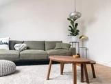 A modern living room features a comfortable gray sofa adorned with stylish cushions, a wooden coffee table
