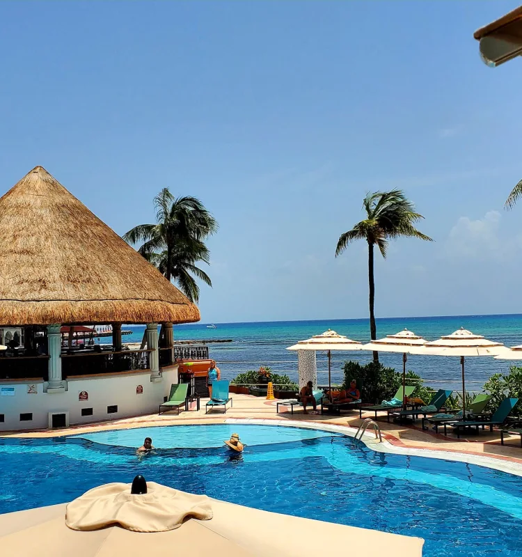 Ocean view cabins with thatched roof and large pool