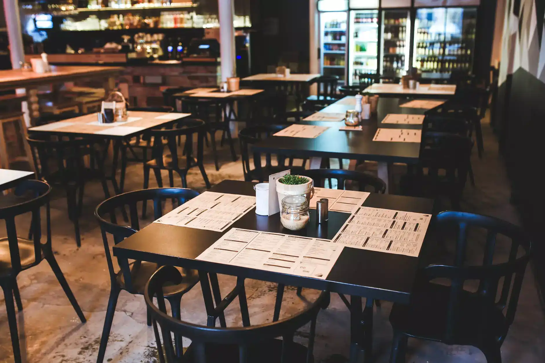 a restaurant with many chairs and tables made of wood