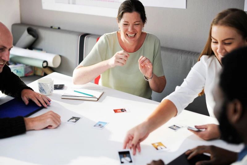 the company sits at the table and plays a board game