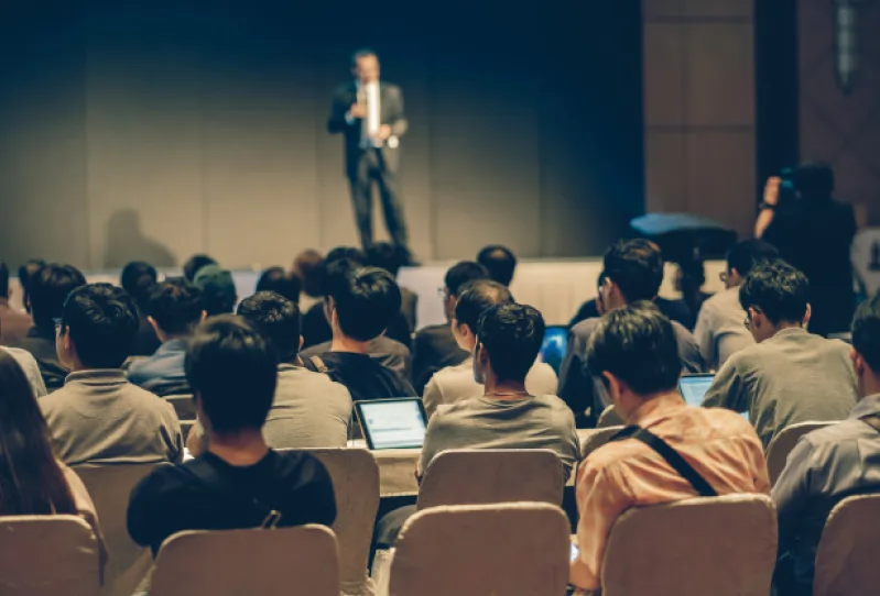 a crowd of people listening to a speaker