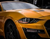Yellow sports car with black accents. Close-up view.