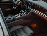 Luxury car interior with leather seats and touchscreen display.