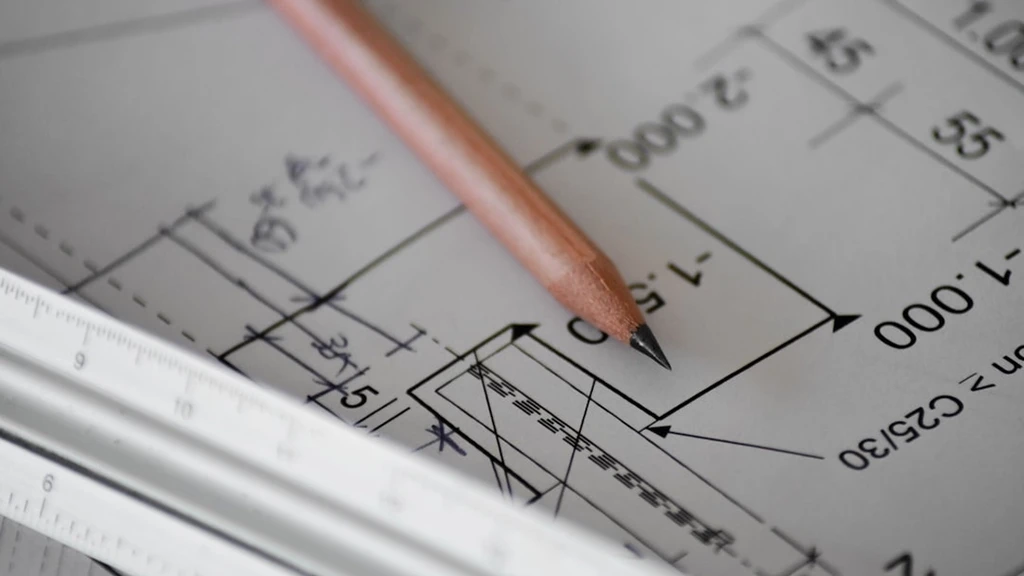 Pencil on architectural blueprints and a ruler.