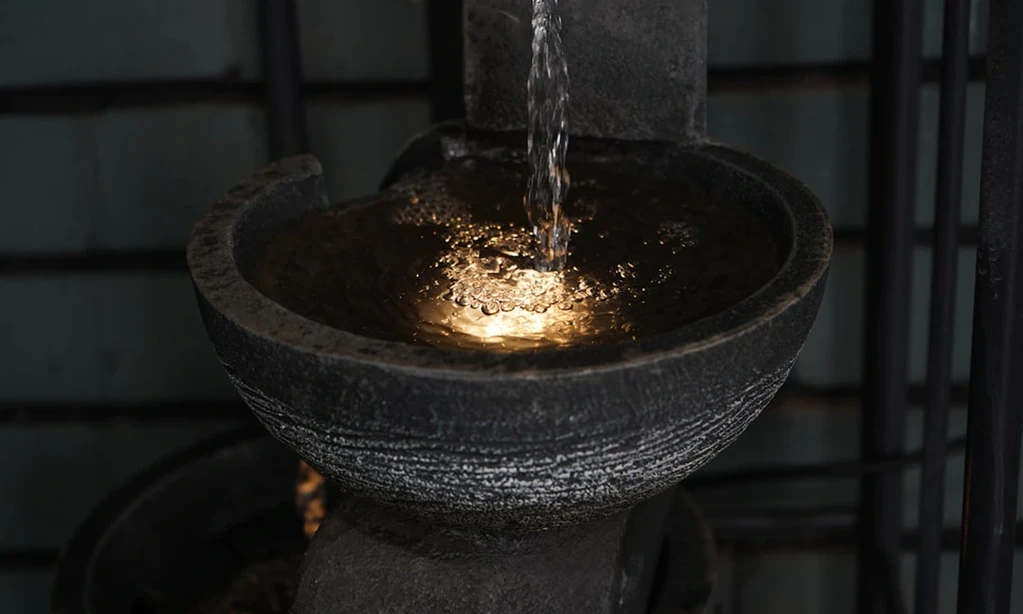 Water flowing into a circular stone basin.