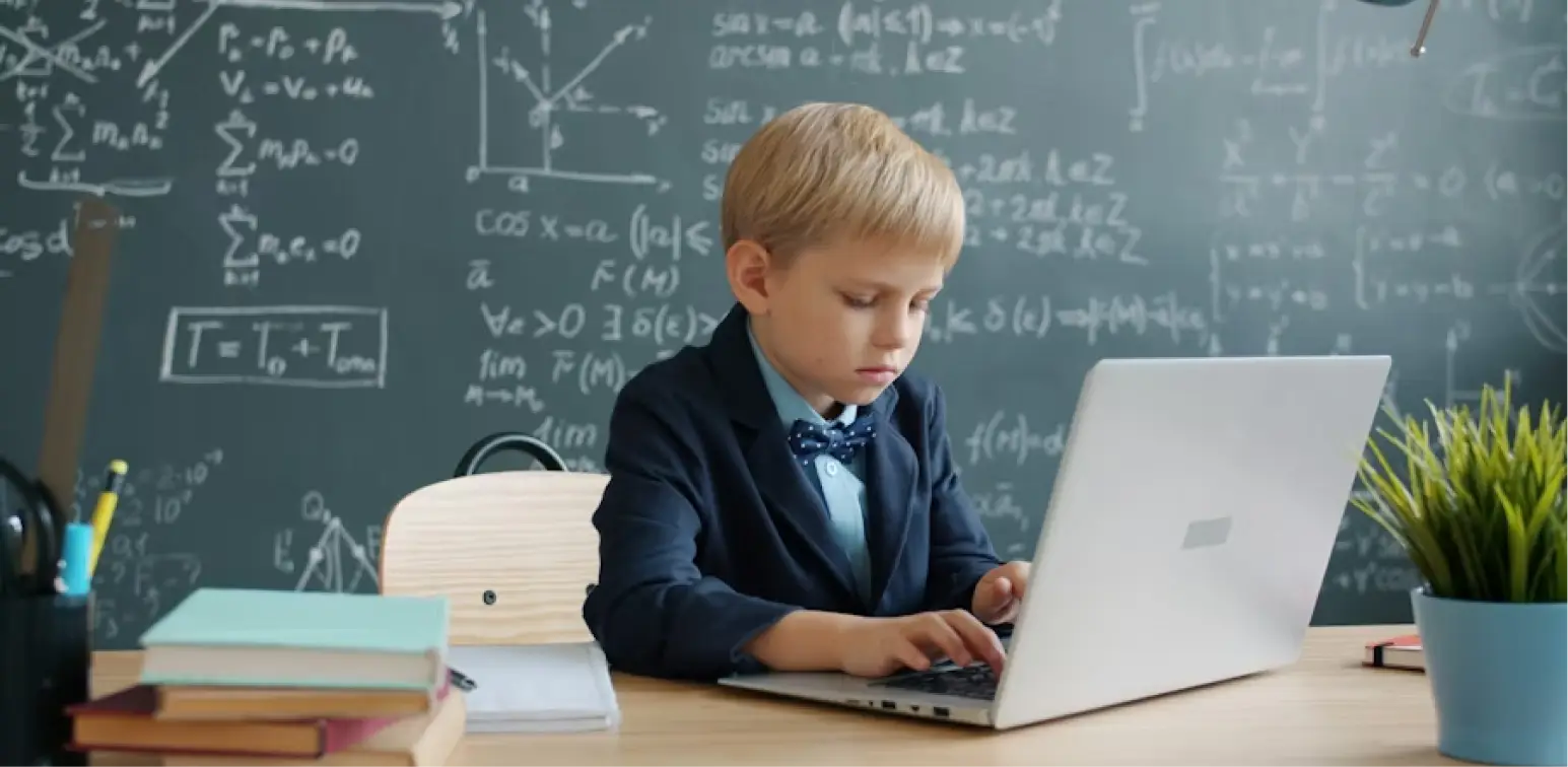 A child sits in class at a laptop