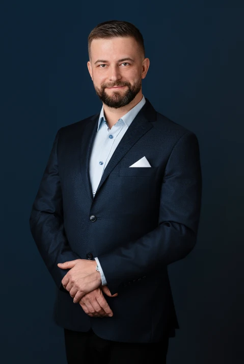 Facet w niebieskiej kurtce szeroko się uśmiecha