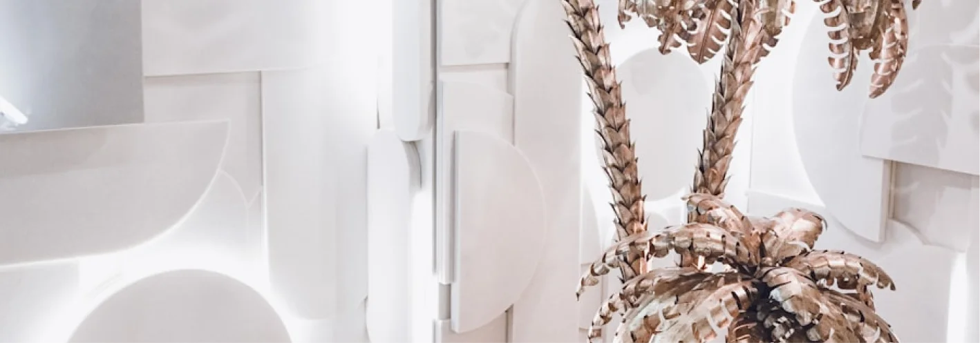 Studio Canopy interior design in Krakow showcasing minimalist white textured walls and decorative artificial palm tree elements